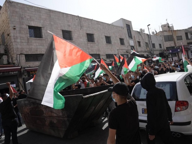 Palestinian flags march in conjunction with the settlers' march in Jerusalem